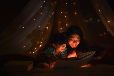 Mother telling story to son in darkroom