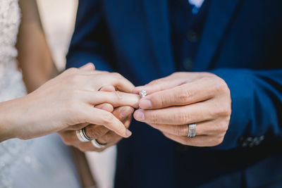 Midsection of couple holding hands