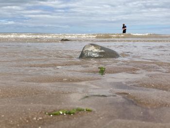 People at beach against sky