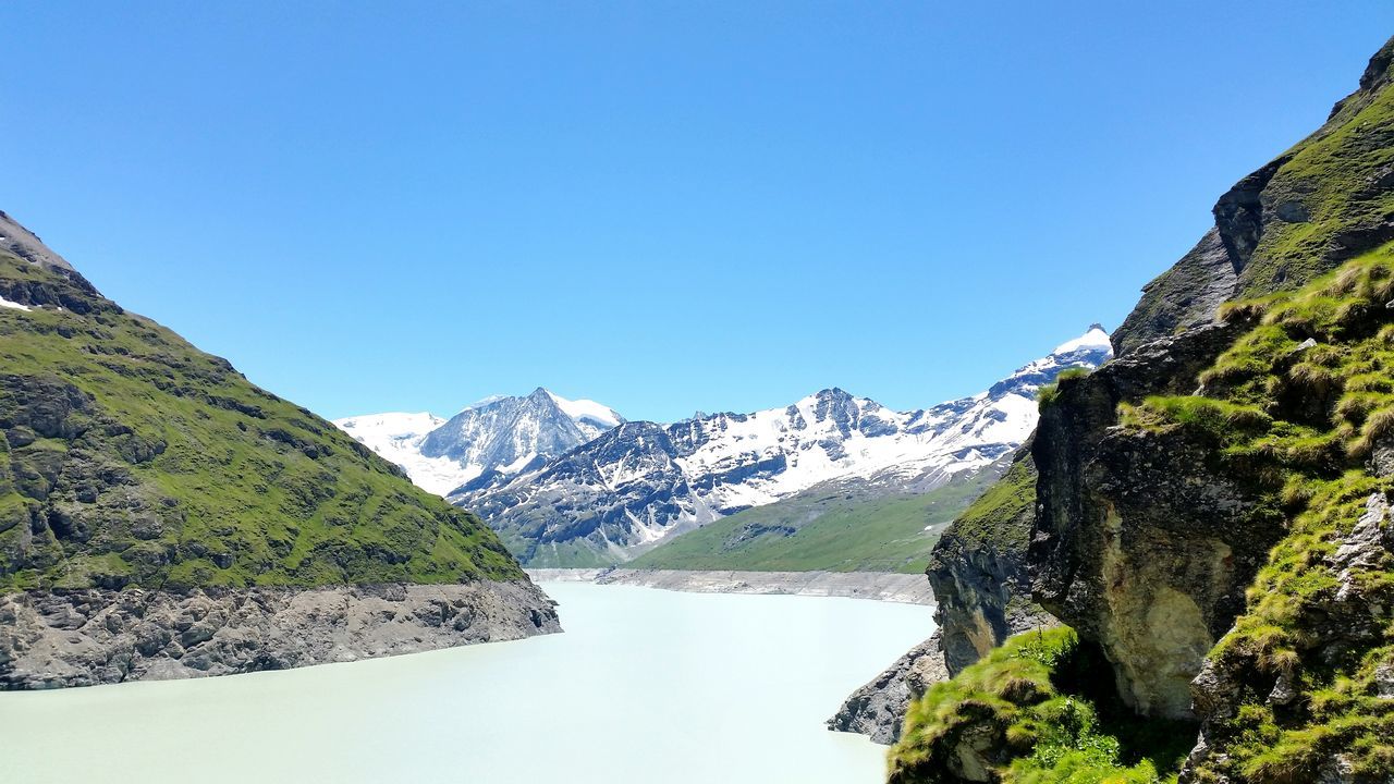 mountain, clear sky, tranquility, tranquil scene, scenics, blue, beauty in nature, mountain range, landscape, nature, non-urban scene, idyllic, day, green color, grass, countryside, outdoors, remote, majestic, non urban scene, no people, valley, physical geography, growth, green, sky, travel destinations, tourism