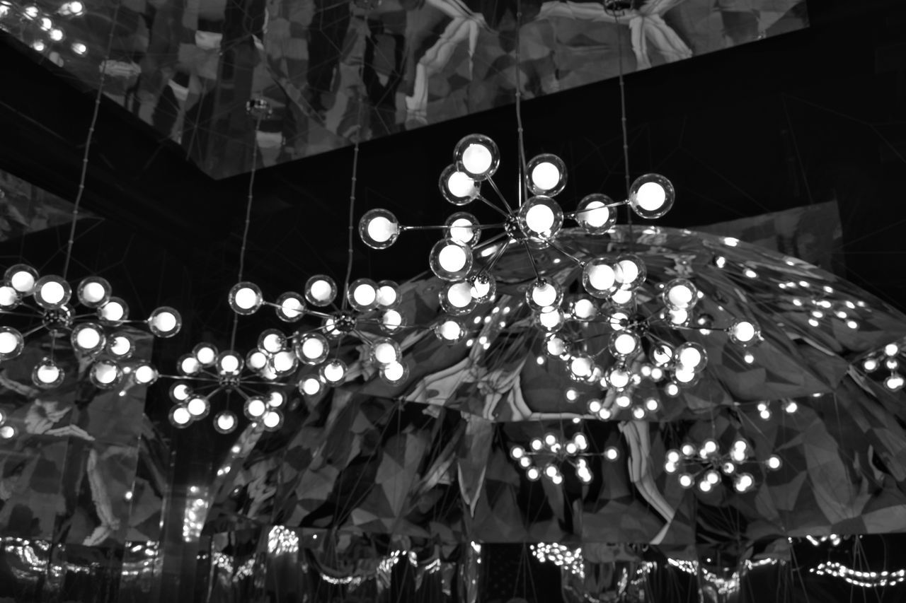 LOW ANGLE VIEW OF ILLUMINATED LIGHTING EQUIPMENT HANGING ON CEILING