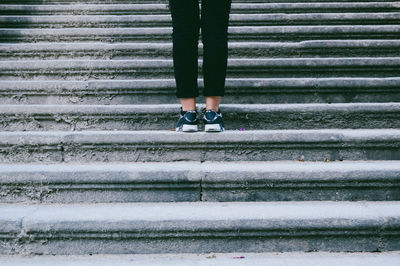 Low section of woman standing on old staircase