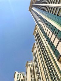 Low angle view of modern buildings against clear blue sky