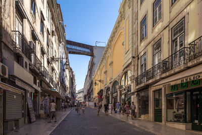 People walking on street amidst buildings in city