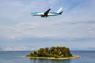 Airplane flying over sea against sky