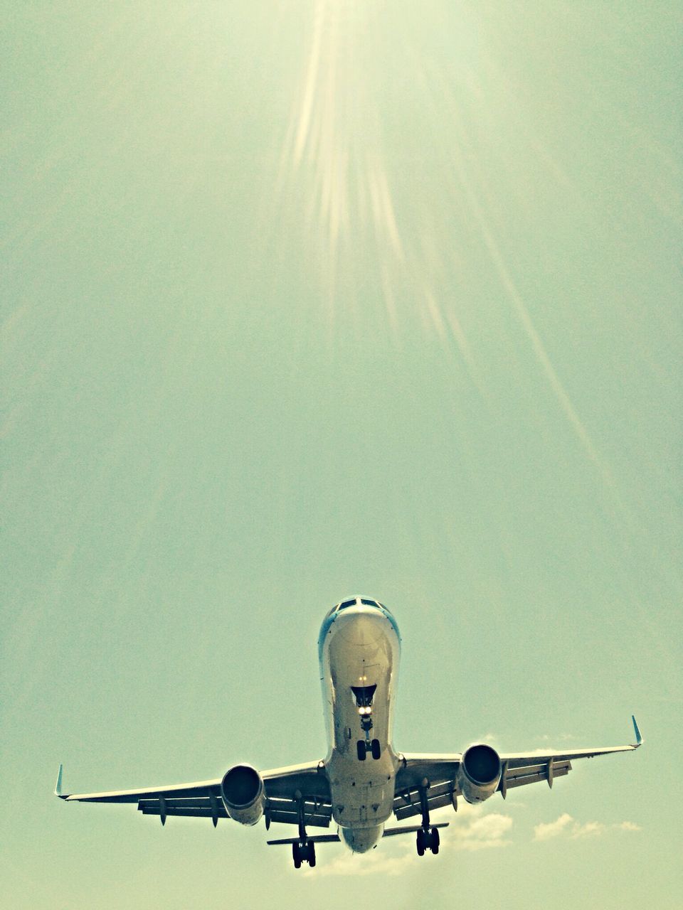 low angle view, airplane, air vehicle, flying, mode of transport, transportation, clear sky, copy space, lighting equipment, street light, mid-air, no people, blue, travel, day, sky, outdoors, aircraft, sunlight, commercial airplane