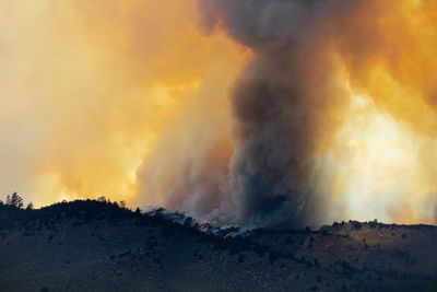 Panoramic view of forest fire against sky