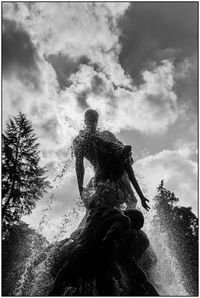 Low angle view of statue against trees against sky