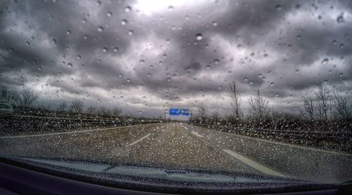 Road seen through wet windshield of car