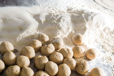 High angle view of dough and flour on counter in kitchen at home