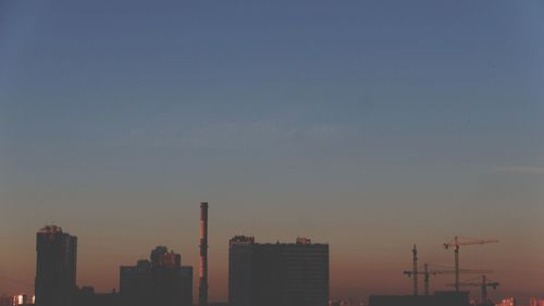 Buildings in city against sky during sunset