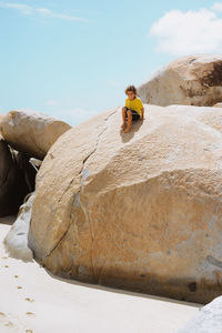 Boy sitting on rock at the beach