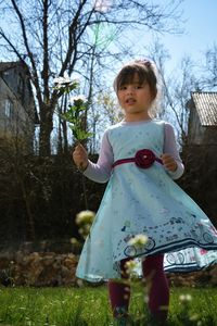 Girl playing on field against trees