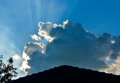 Low angle view of silhouette roof against sky