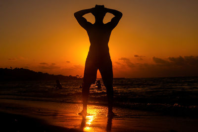 A young man wearing a hat at sunset on the beach