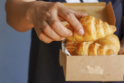 Close-up of hand holding bread in box