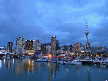 River by illuminated buildings against sky