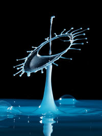 Close-up of water splashing over black background