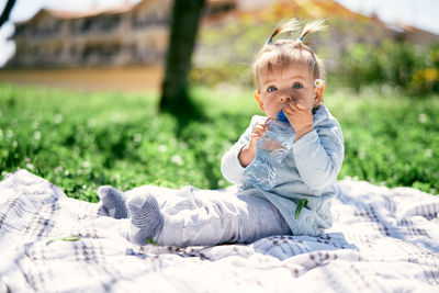 Portrait of cute girl sitting on grass