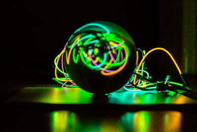 Close-up of illuminated lighting equipment against black background