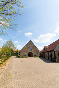 Footpath amidst buildings against sky