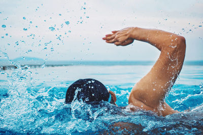 Rear view of man swimming in pool