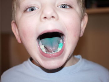 Portrait of boy showing turquoise tongue