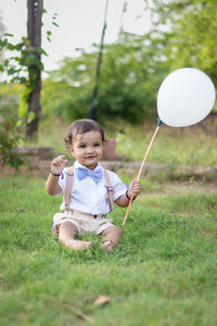 Portrait of cute girl playing with ball on field