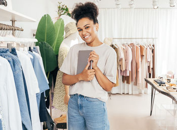 Portrait of smiling young woman standing on mobile phone