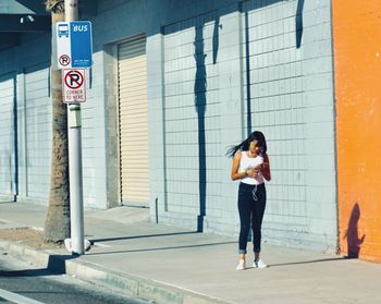 Full length of woman standing against building