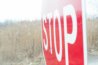 Close-up of red arrow sign against sky