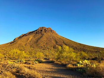 Scenic view of land against clear blue sky