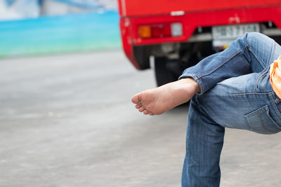 Low section of man sitting on road