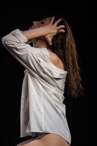 Midsection of woman standing against black background