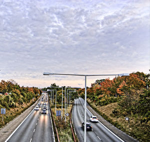 High angle view of vehicles on road leading towards sea