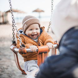 Close-up of boy swinging at playground