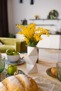 Bright spring mimosa in a ceramic geometric vase in the decor serving a festive or home table 