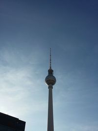 Low angle view of communications tower against blue sky