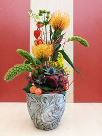 Close-up of potted plant on table against orange wall