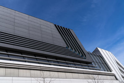 Low angle view of modern building against blue sky