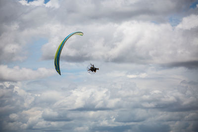 Low angle view of person paragliding against sky