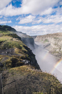 Scenic view of waterfall against sky