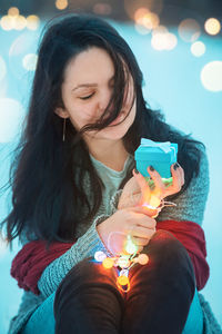 Young woman with christmas decorations during sunset