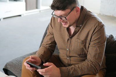 Side view of young man using mobile phone