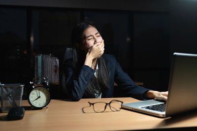 Woman using mobile phone while sitting on table