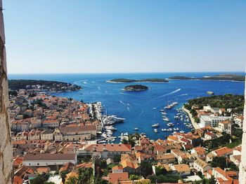 High angle view of townscape by sea against clear sky