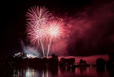 Firework display over river at night