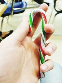 Close-up of hand holding candy cane