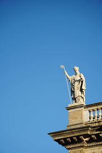 Low angle view of statue against blue sky