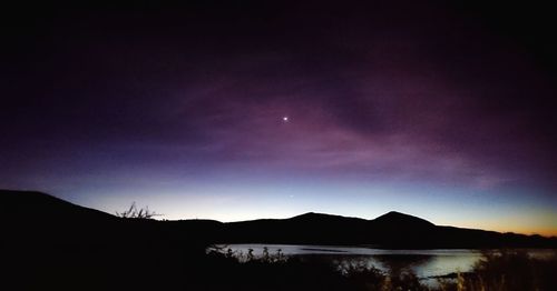 Scenic view of lake against sky at night